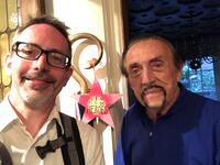 Photo of author on the left and Philip Zimbardo on the right with a small red star behind them that reads "Any of us can be heroes!"